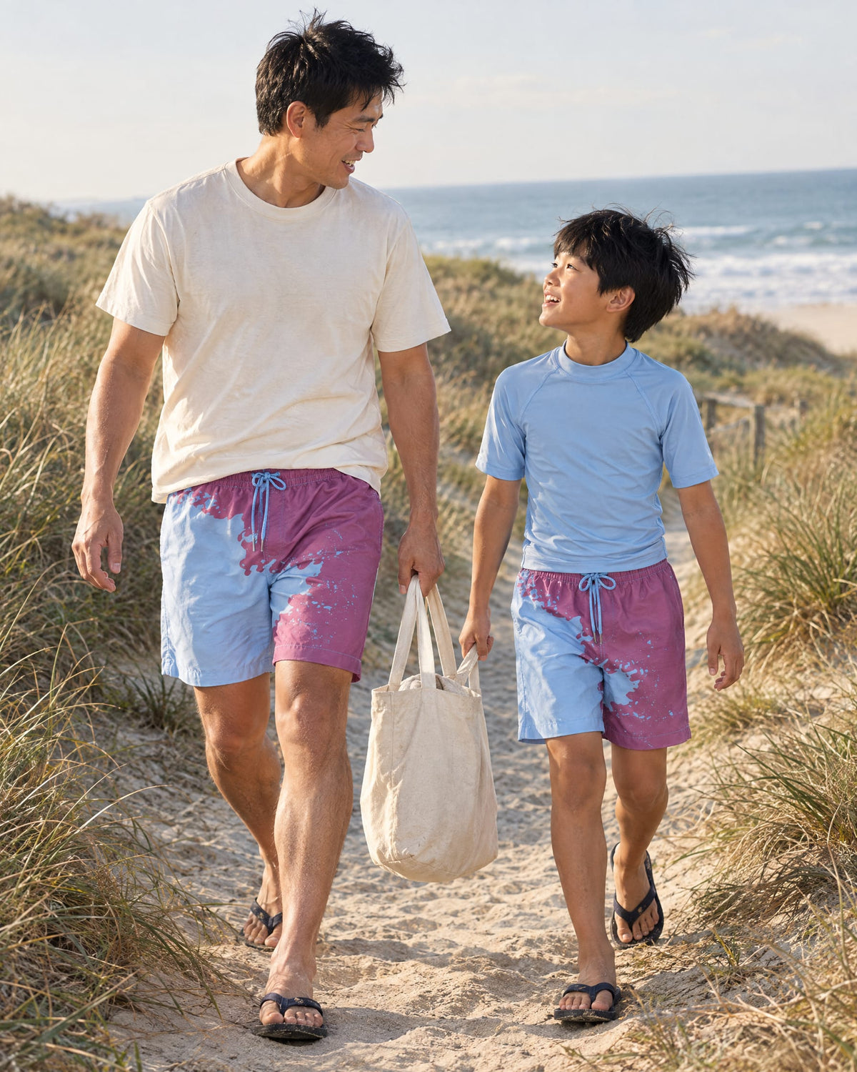 Dad and son on a dune path in matching Shift Purple to Blue swim shorts