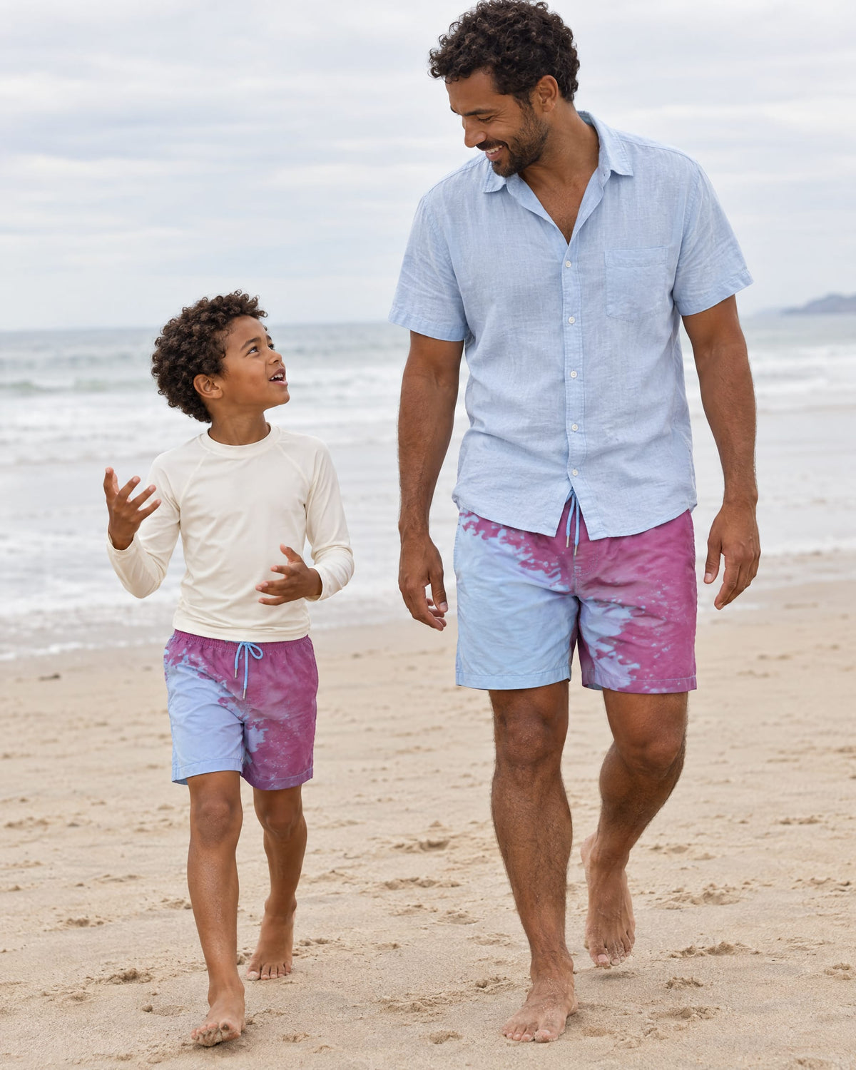 Dad and son walking on the beach in matching Shift Purple to Blue swim shorts