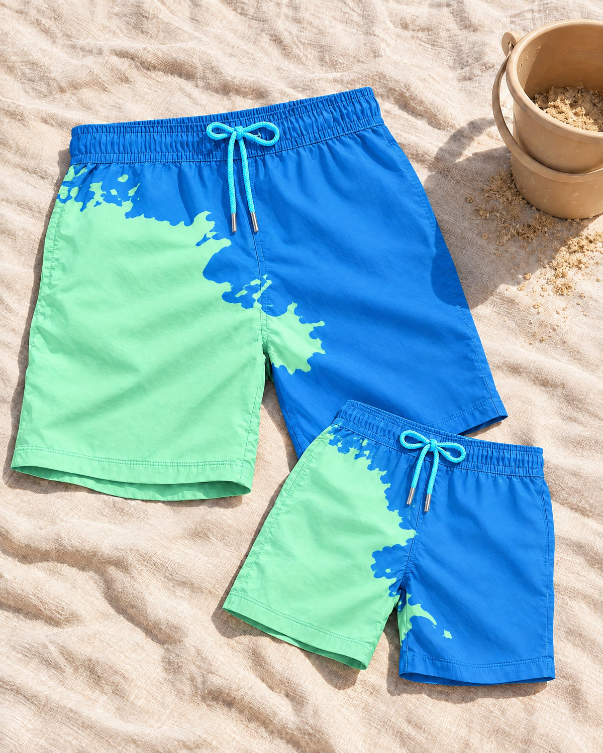 Dad & Mini matching colour-changing swim shorts set in Blue to Green on the sand