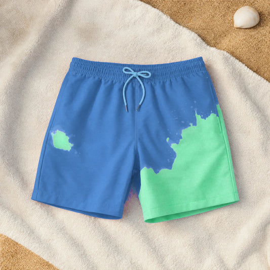 Kids' colour-changing swim shorts in Blue to Green on a beach towel, green where the water hit