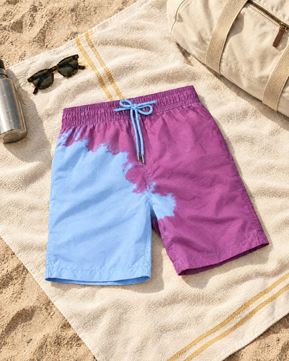 The Original colour-changing swim shorts in Purple to Blue on a beach towel, half wet