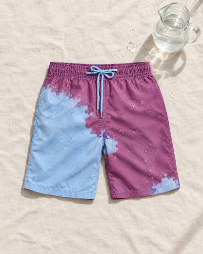 The Original colour-changing swim shorts in Purple to Blue, splashed with water on sand