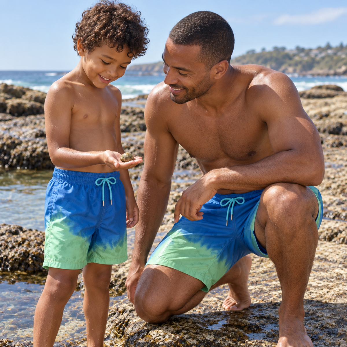 Dad and son exploring rock pools in matching Shift Blue to Green swim shorts