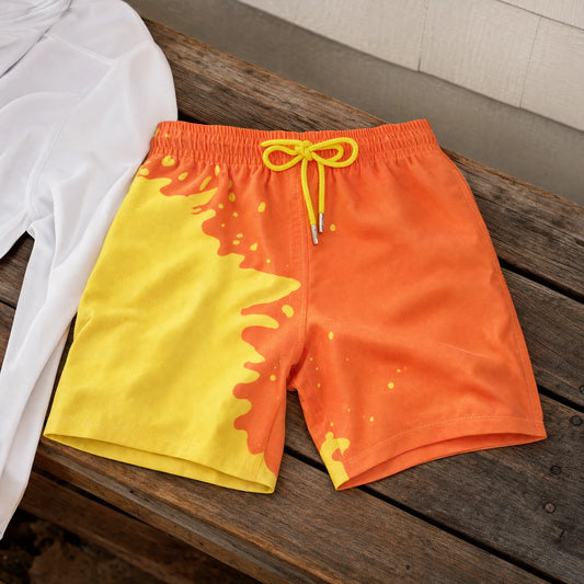 Shift kids' colour-changing swim shorts, Orange to Yellow, on a timber bench