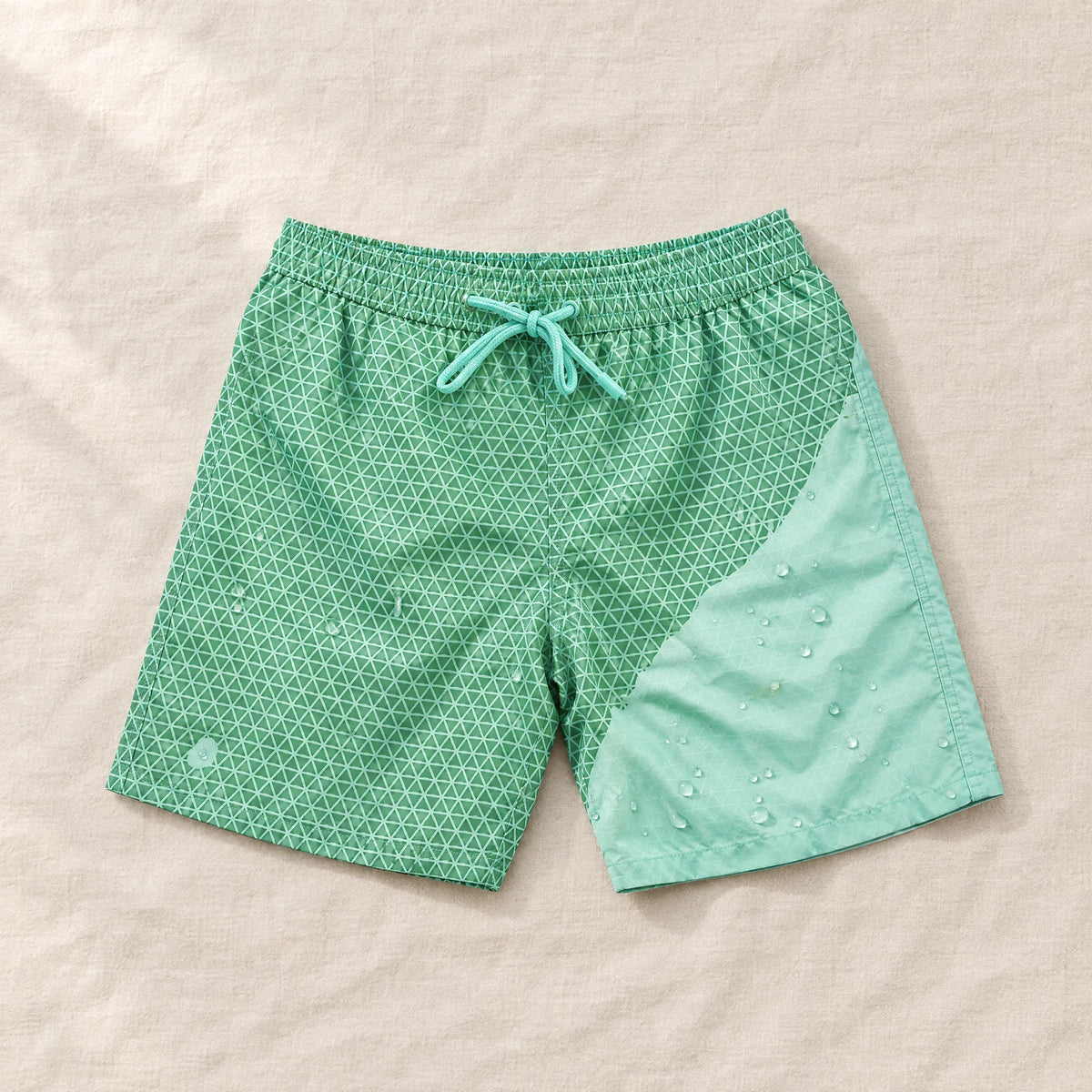 Shift Geometric Green to Mint swim shorts on linen, showing both colours