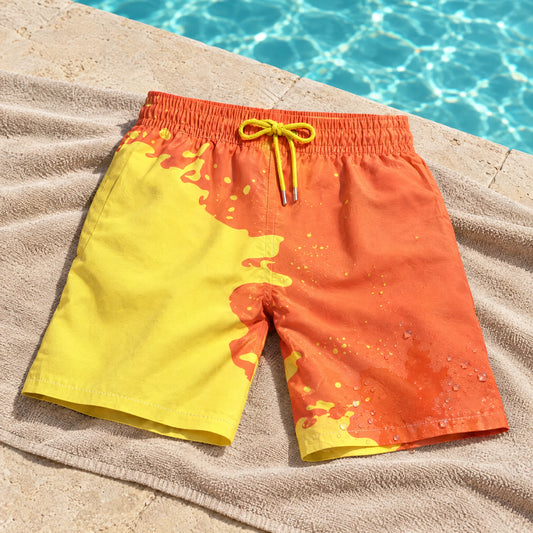 Shift Orange to Yellow swim shorts on a poolside towel, showing both colours